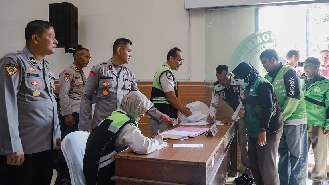 Suasana pembagian sembako dan cek kesehatan gratis bagi ojek online di Polres Jombang.